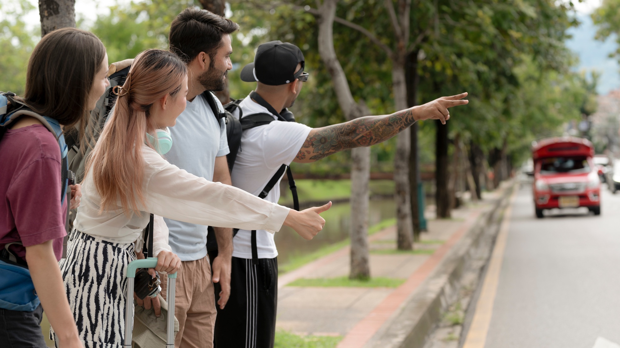 Foreign tourists hitchhike in Chiang Mai in Thailand.