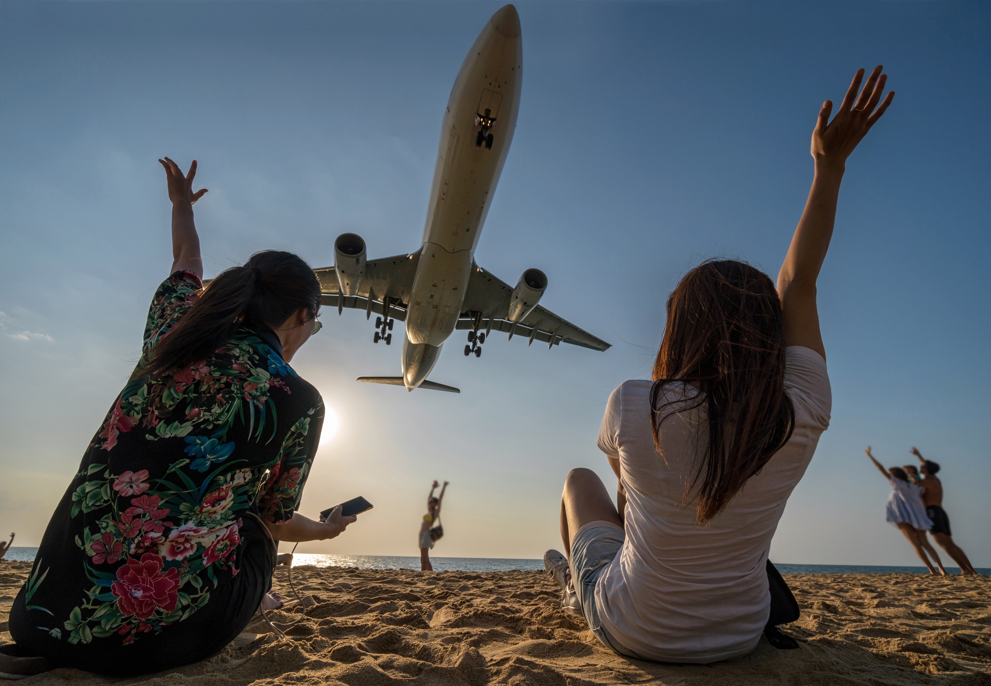 Scene of Two traveler woman showing hand and funning with Airplane landing closely