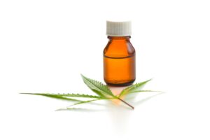 Marijuana cannabis leaf and cannabis oil extract in jar.